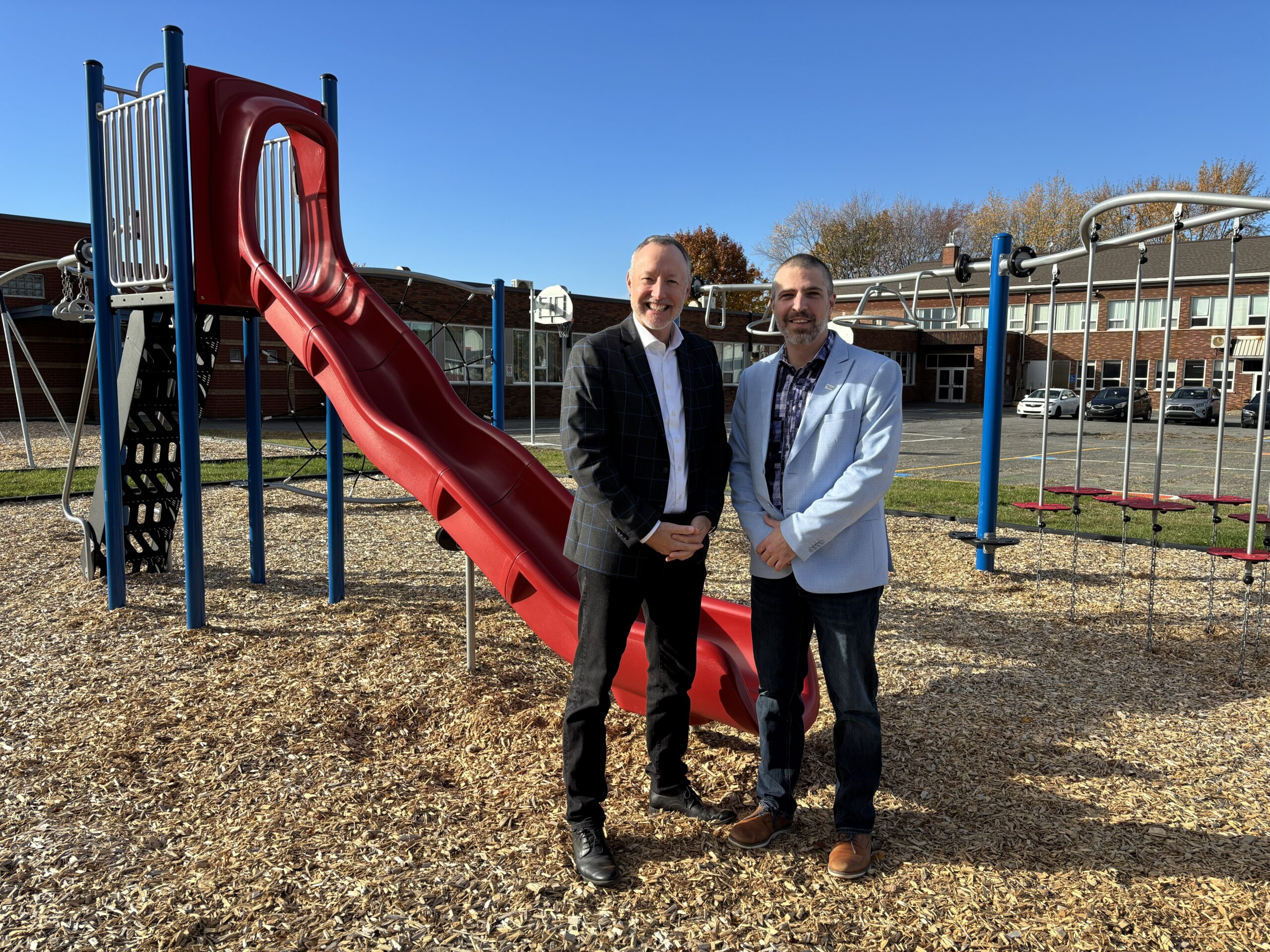 Le député de Richelieu, Jean-Bernard Émond, et le directeur général du Centre de services scolaire de Sorel-Tracy, Jonathan Charbonneau, devant les nouveaux modules de jeux installés dans la cour de l’école